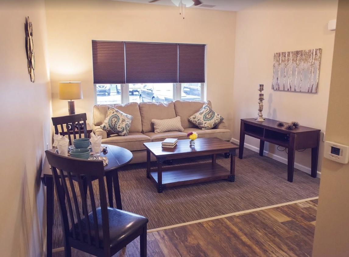 A cozy living room with a sofa, coffee table, and wooden furniture.