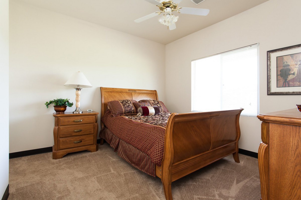 A cozy bedroom with a wooden bed, nightstand, and elegant decor.