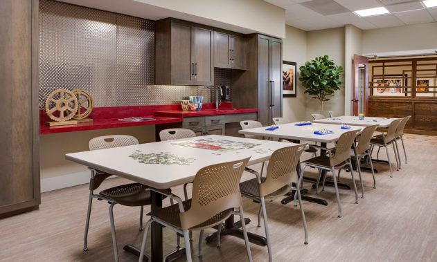 A modern kitchen and dining area with tables, chairs, and cabinetry.