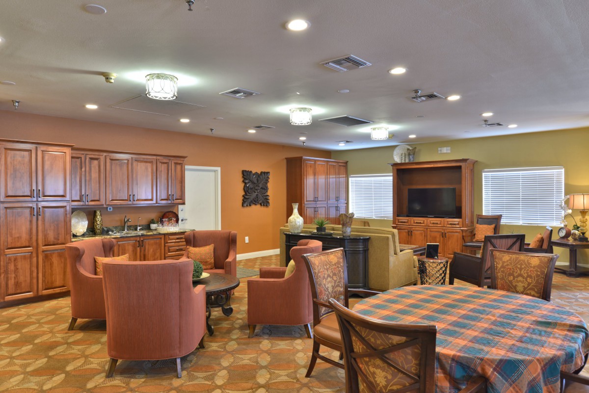 A cozy communal living area with a kitchen, seating, and entertainment setup.