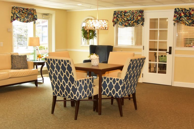 A cozy dining room with a wooden table and patterned chairs.