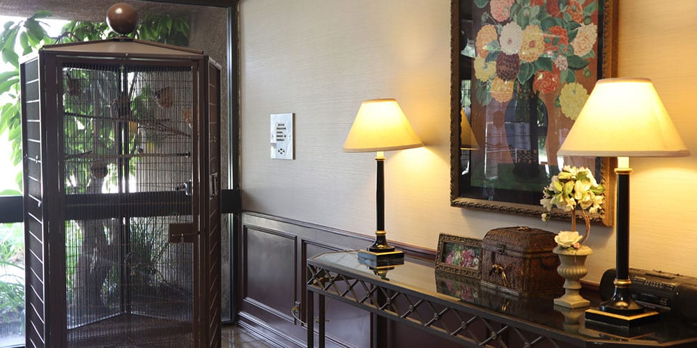 A cozy hallway featuring a table with a lamp and decorative items, complemented by artwork on the wall.