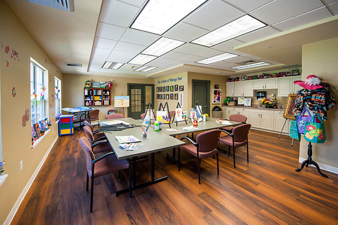 A modern conference room with a large meeting table and chairs, featuring a stylish interior and hardwood flooring.