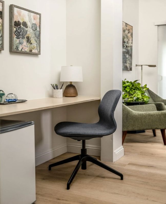 A modern home office setup with a desk, comfortable chair, and decorative elements.
