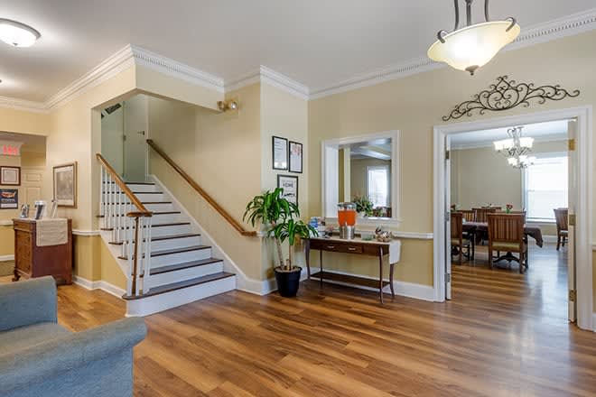 A welcoming foyer with a staircase, hardwood flooring, and elegant decor.