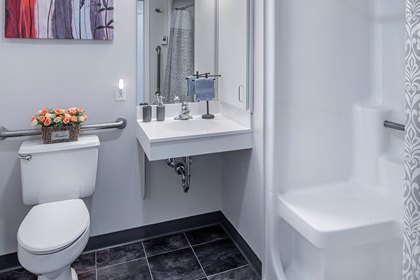 A modern and clean bathroom featuring a sink with a mirror and toilet.