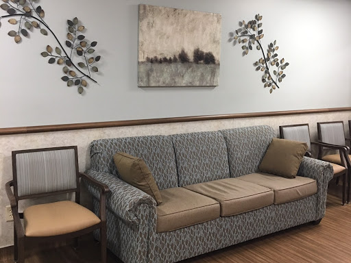 A cozy living room setup featuring a patterned couch with throw pillows, complemented by wall decor and artwork.