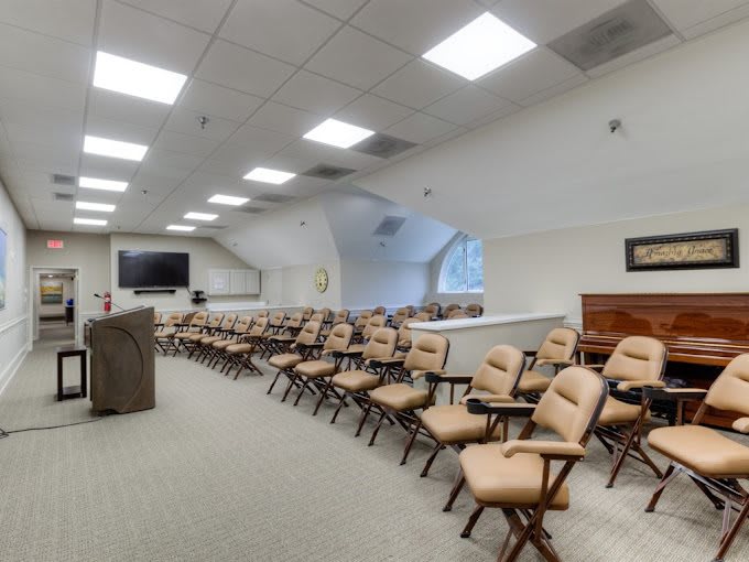 An empty conference room with rows of beige chairs arranged neatly, ready for a meeting or lecture.