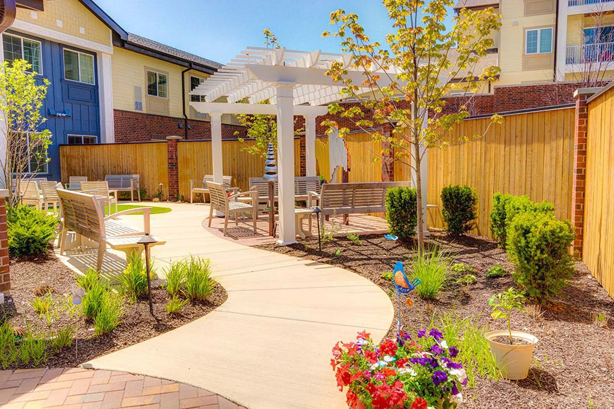 A beautifully landscaped garden with a winding path and pergola.