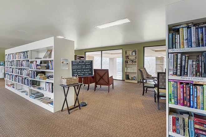 A cozy library interior with bookshelves and seating areas for reading.