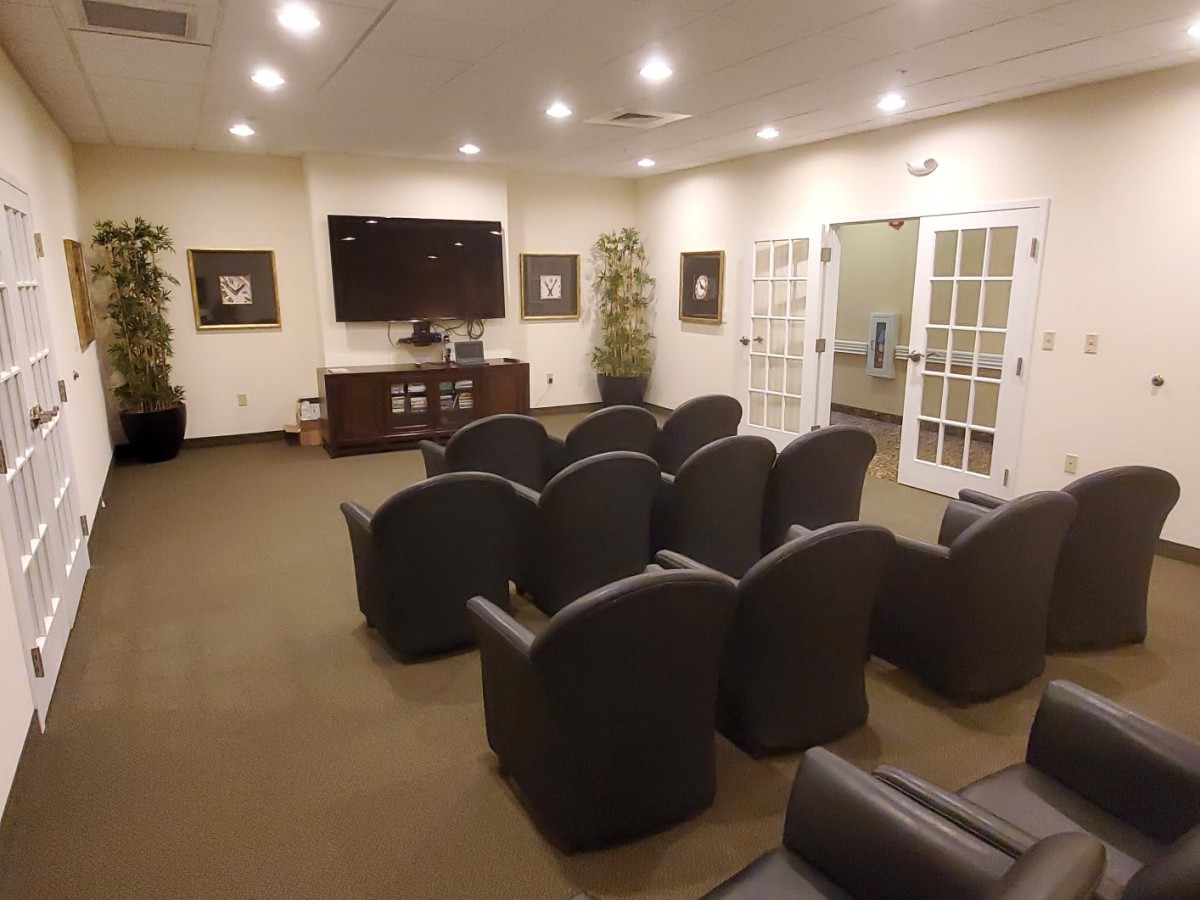 A modern waiting room with comfortable seating and a television.