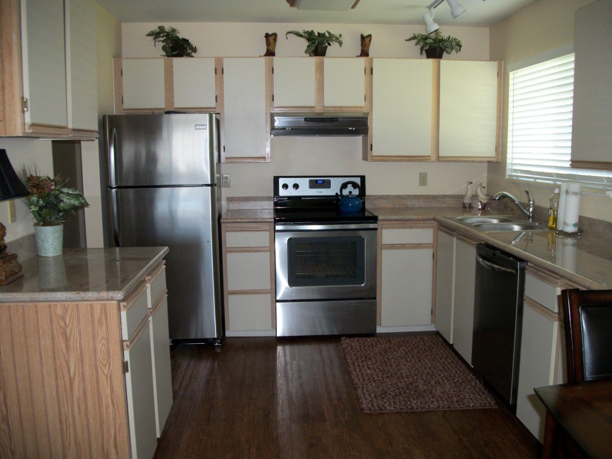 Modern kitchen with stainless steel appliances and wooden cabinets.