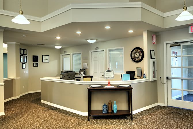 A modern reception desk in an office setting with neutral decor and soft lighting.