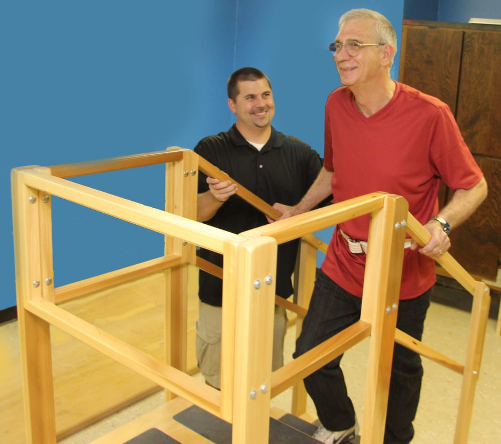 A therapist assists a patient during a rehabilitation exercise session.