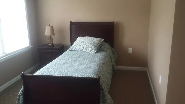 A minimalist bedroom with a single bed and nightstand.