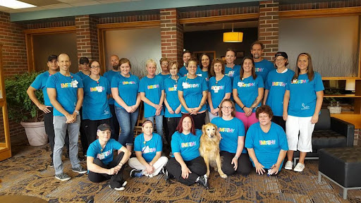A vibrant team gathering with smiles all around, showcasing camaraderie and community spirit.
