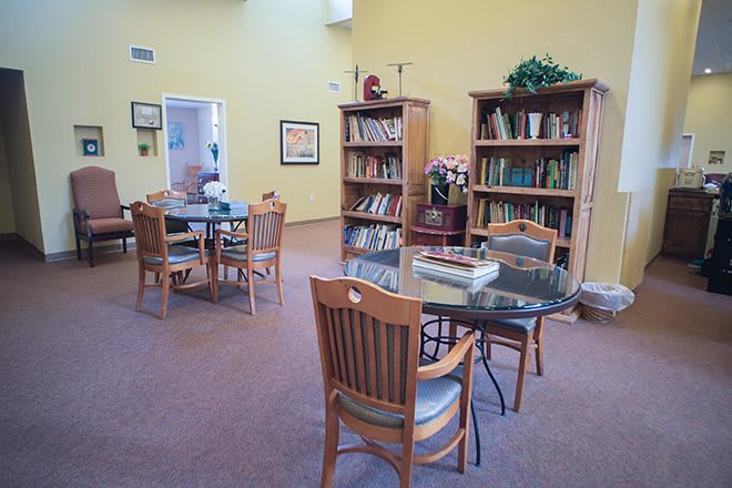 A cozy reading room with bookshelves and tables set for studying.