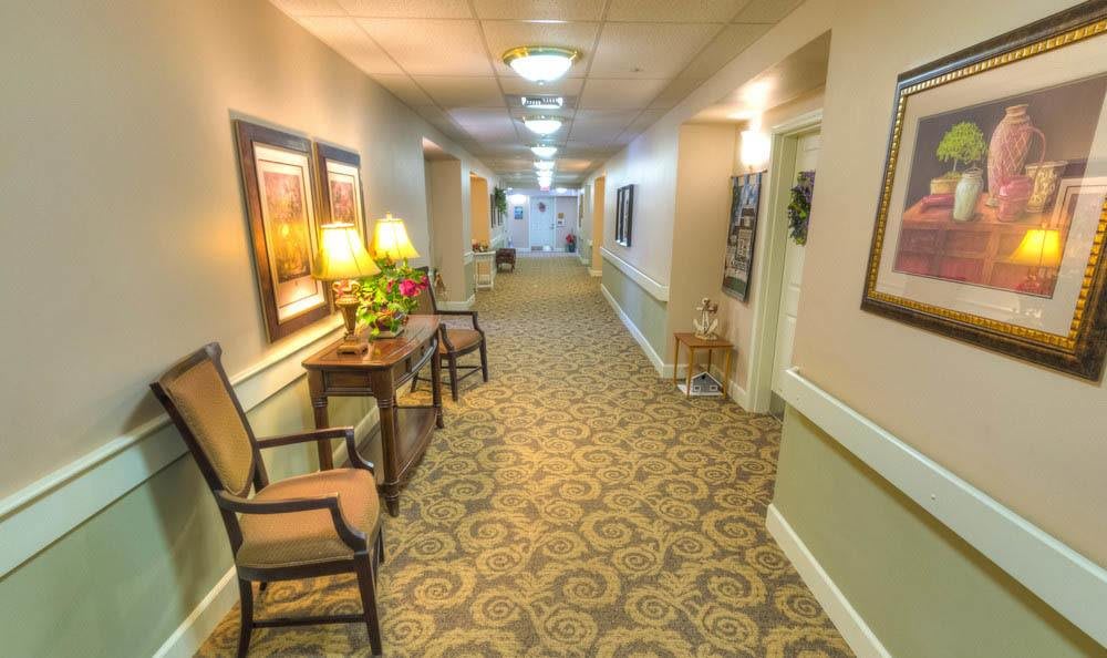 A well-lit hallway with decorative furniture and carpeting.