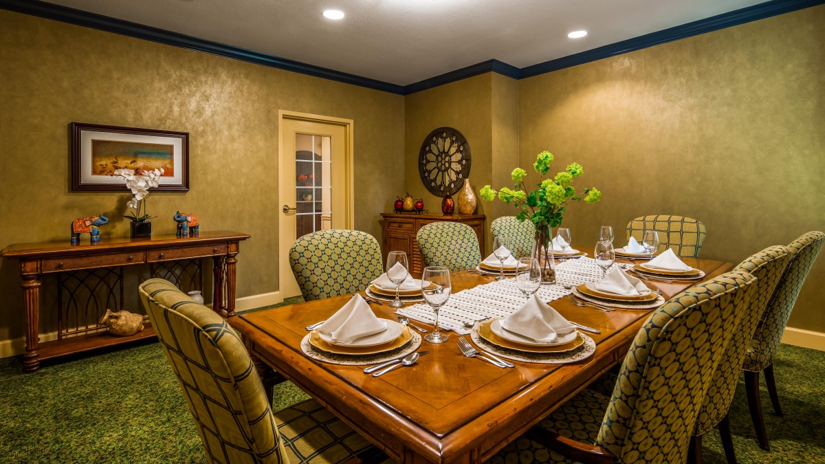 An elegant dining room with a beautifully set table, ready for a formal dinner.