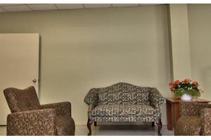 A cozy seating area with a patterned sofa, armchair, and small side table.