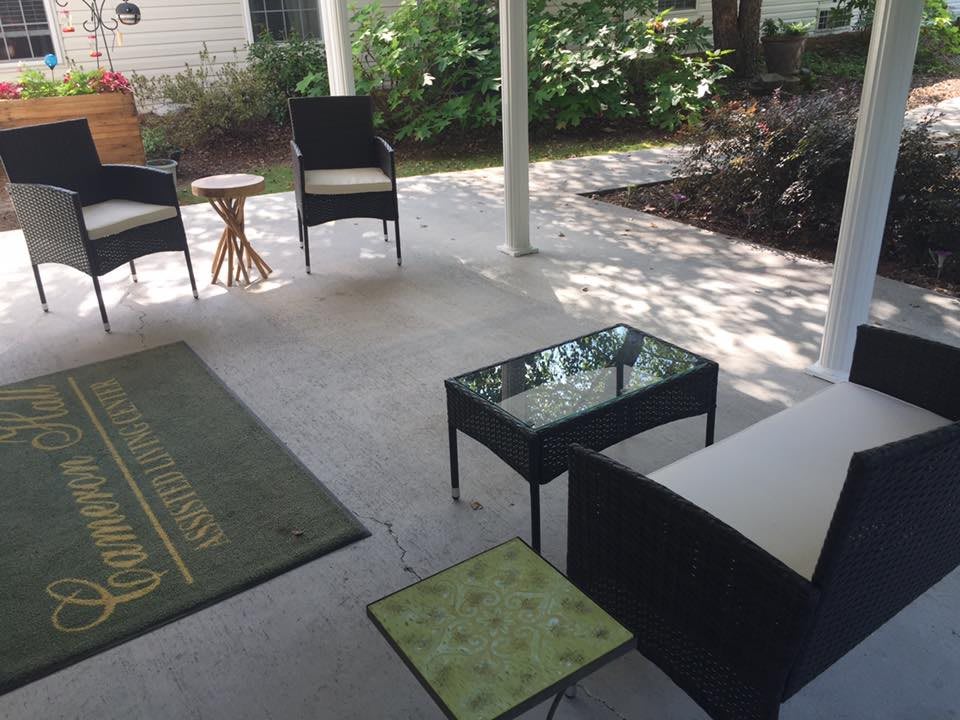 A cozy patio with seating and a small table under a covered area.