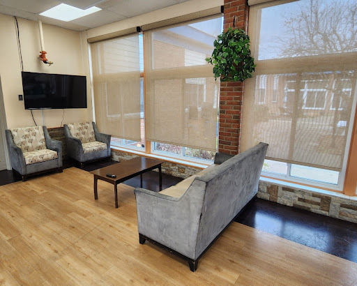 A cozy and modern living area featuring a comfortable sofa, stylish chairs, and plenty of natural light.