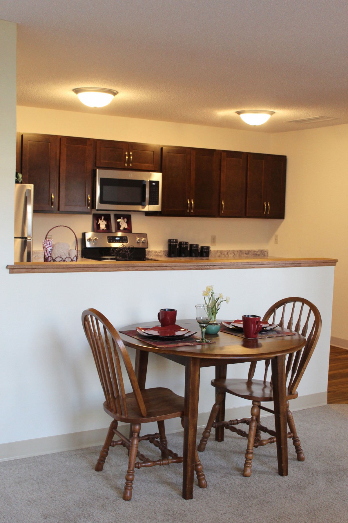 Compact kitchen and dining area with wooden furniture and modern appliances.