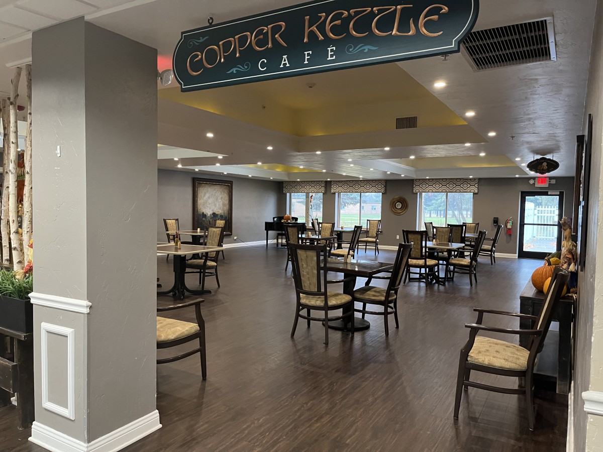 The Copper Kettle Cafe features an inviting seating area with wooden flooring and ample natural light.