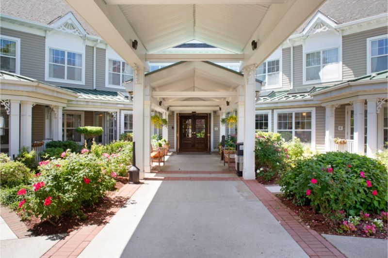 A well-maintained building entrance with a covered walkway and vibrant landscaping.