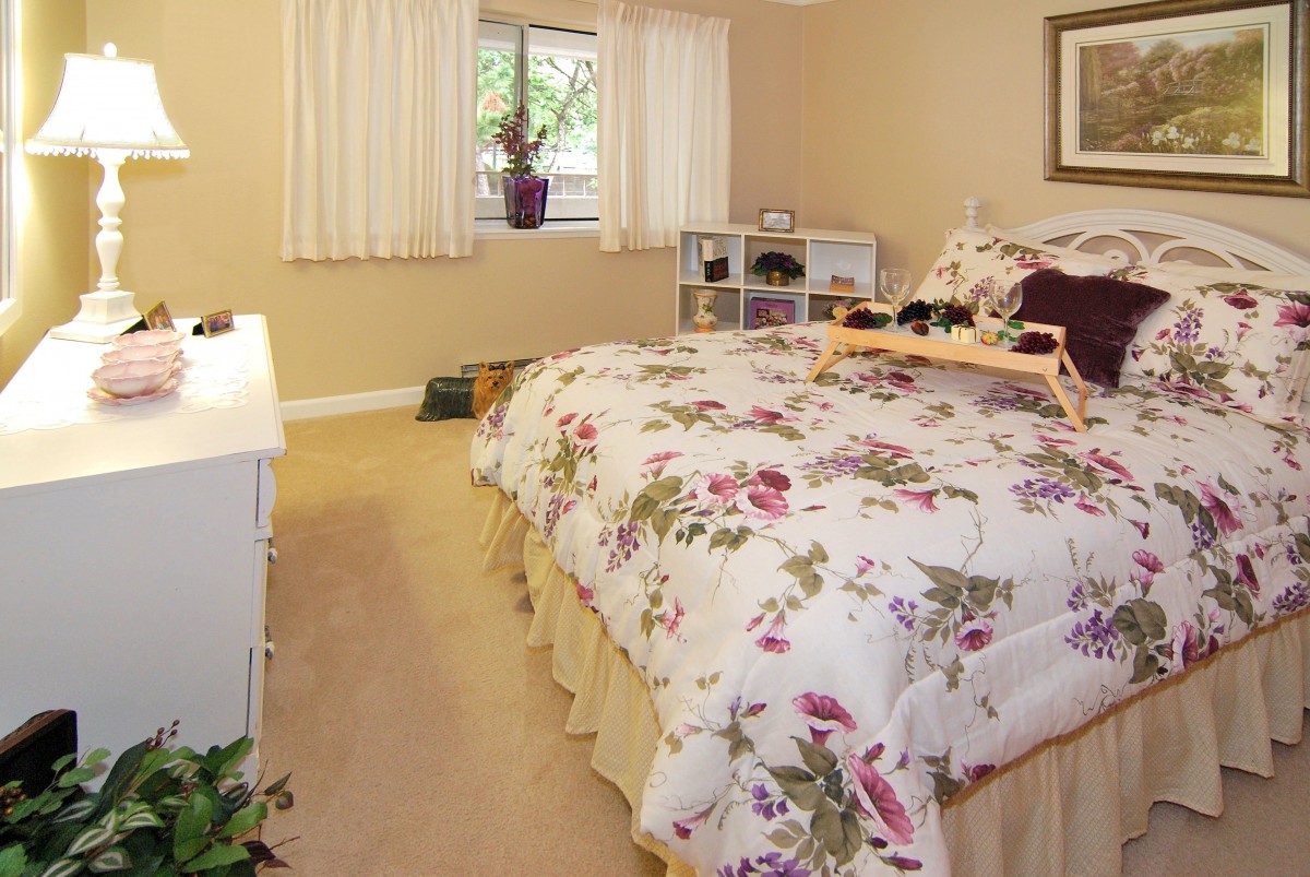 A cozy bedroom with floral bedding and warm decor.