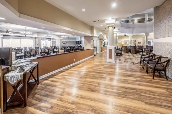 A spacious and modern restaurant interior with wooden floors and empty dining tables.