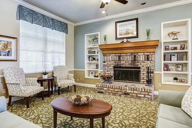 A cozy living room with a brick fireplace and elegant furnishings.