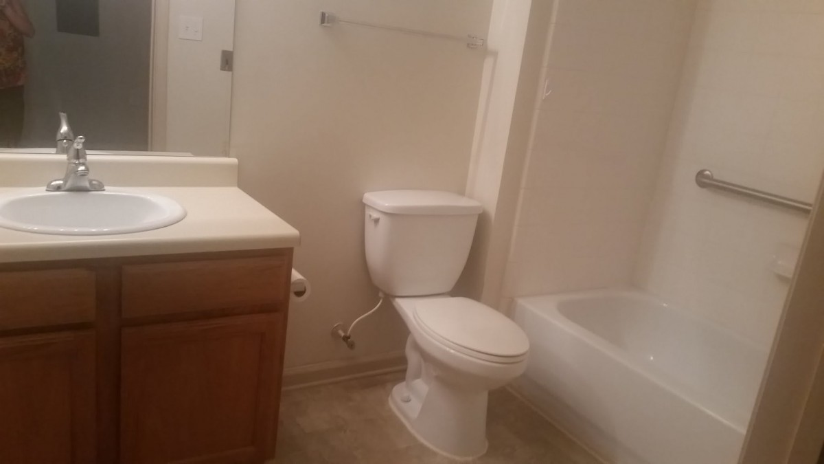 A simple bathroom with a toilet, sink, and bathtub.