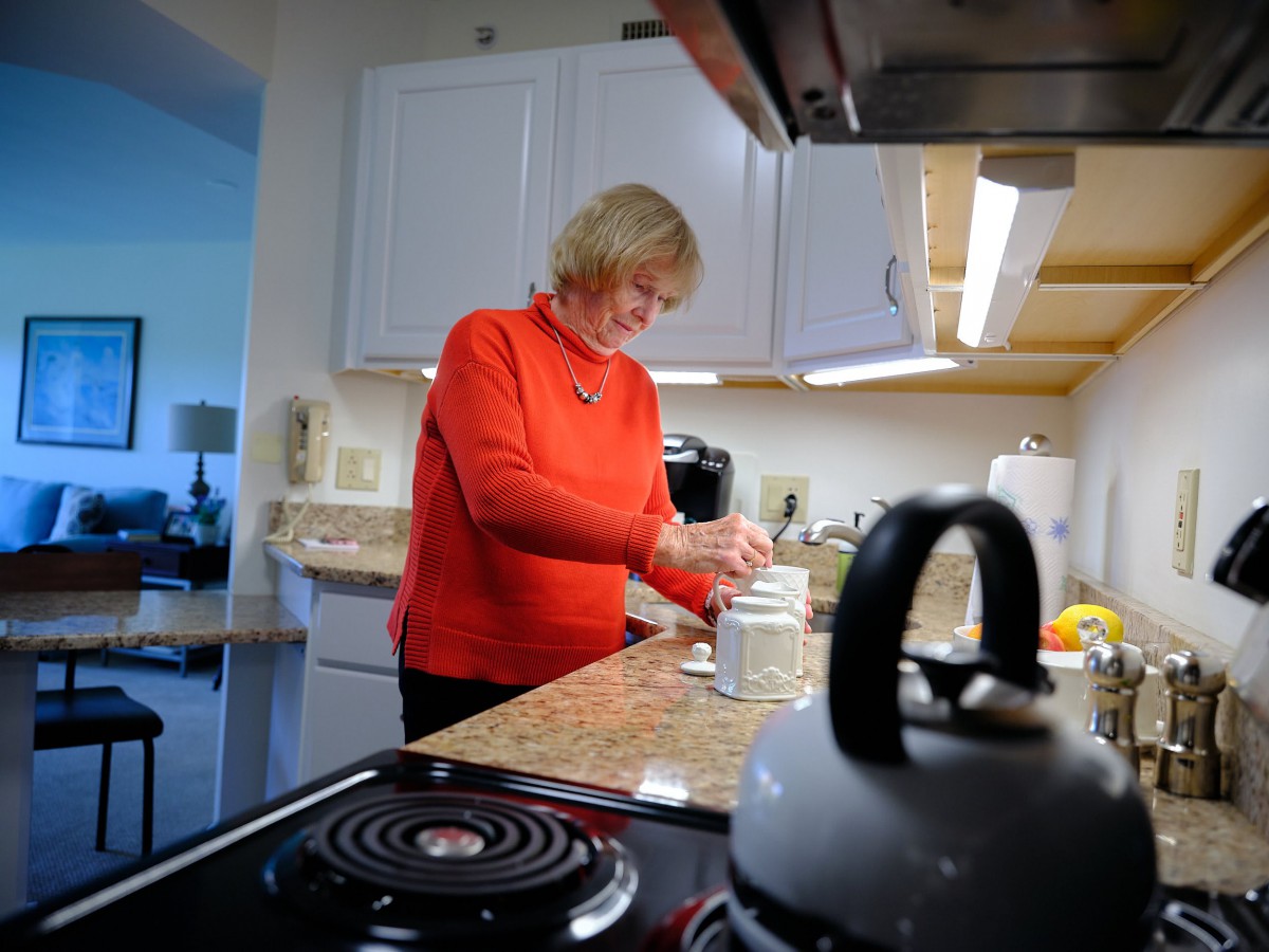 A woman preparing food in a kitchen setting.