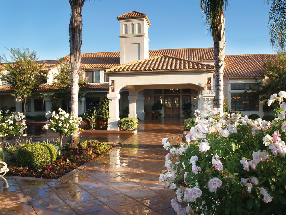 A beautiful hotel entrance surrounded by lush landscaping and palm trees.