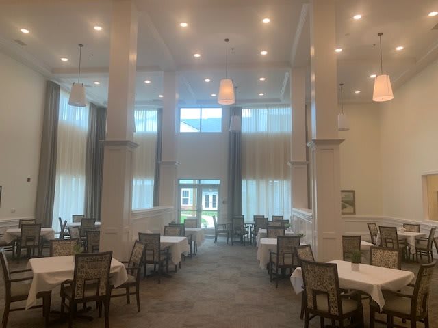 A spacious and modern dining area with high ceilings and neatly arranged tables and chairs.