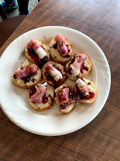 A delightful platter of bite-sized appetizers topped with prosciutto and a hint of sweetness.