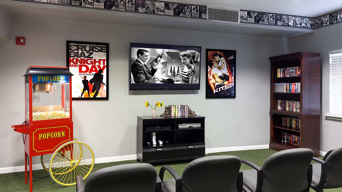A cozy home theater setup featuring classic movie posters and a wall-mounted television.