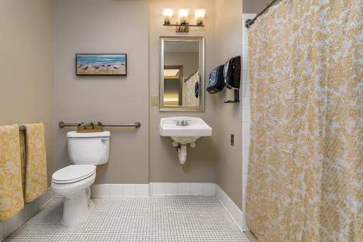 A well-organized bathroom featuring a toilet, sink, and a shower area with decorative elements.