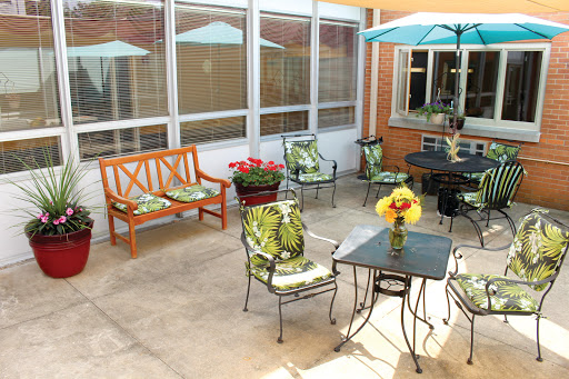 A cozy outdoor patio area with seating, a table, and vibrant flowers, perfect for relaxation.