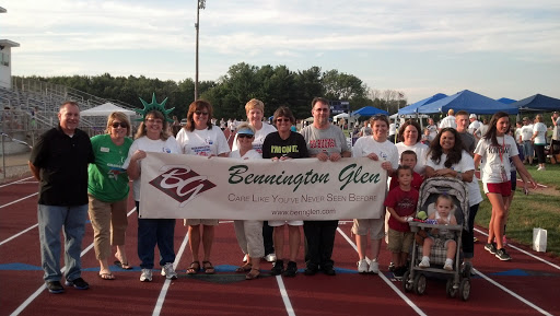 Members of the community gather to show support at an event, proudly holding a banner for Bennington Glen.