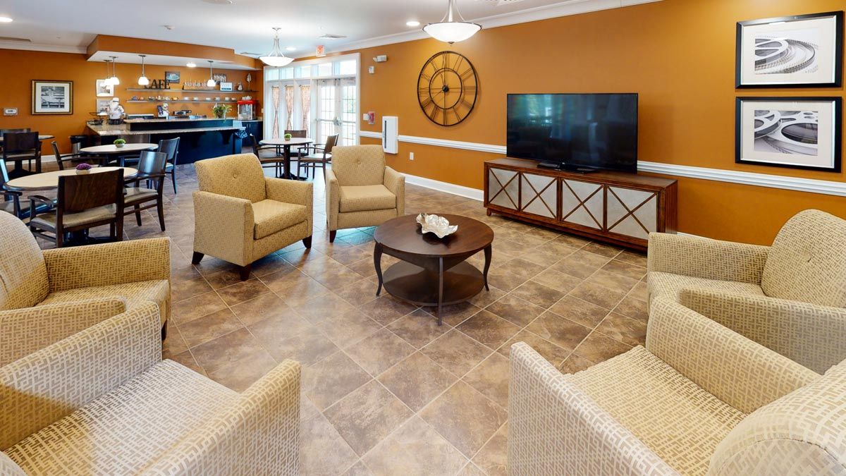 A cozy living room with comfortable armchairs, a television, and elegant decor.
