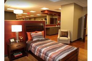 A modern bedroom with striped bedding and ambient lighting.