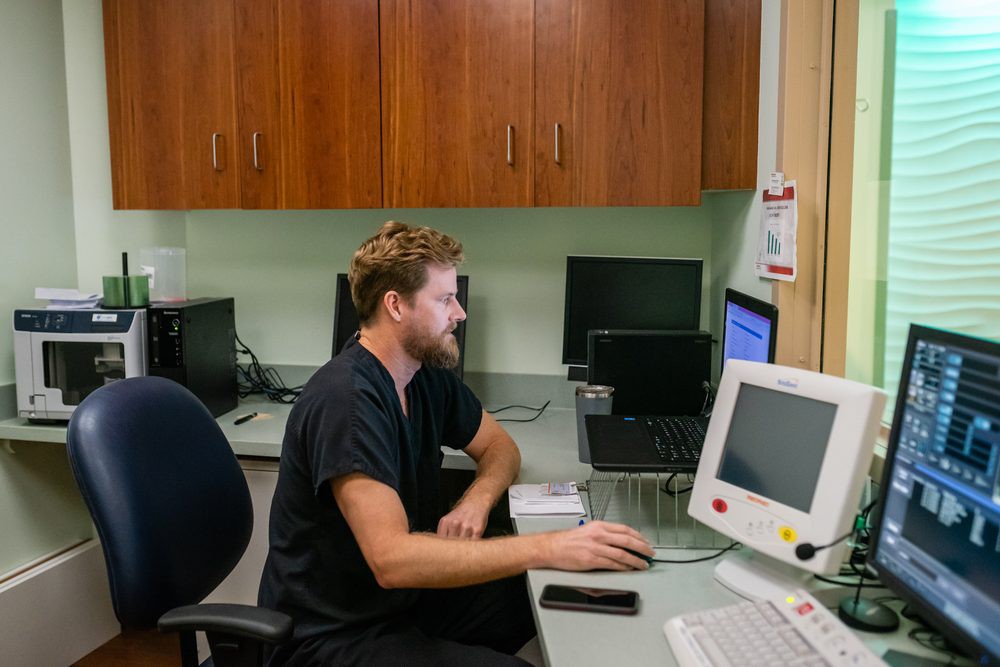 A man working at a computer in an office setting.