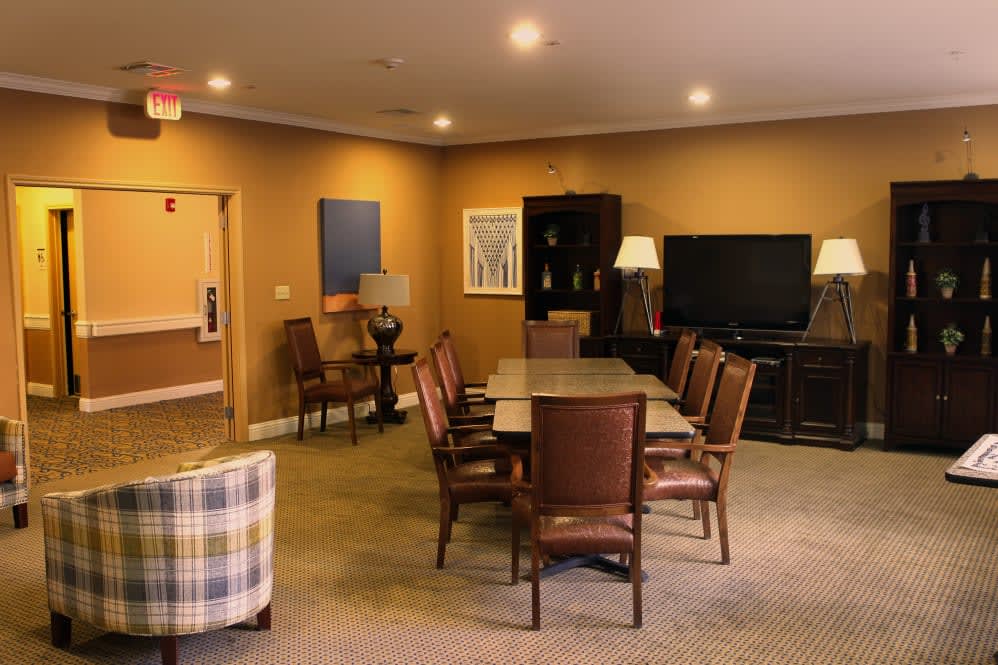 A cozy conference room with a table, chairs, and a television for meetings.