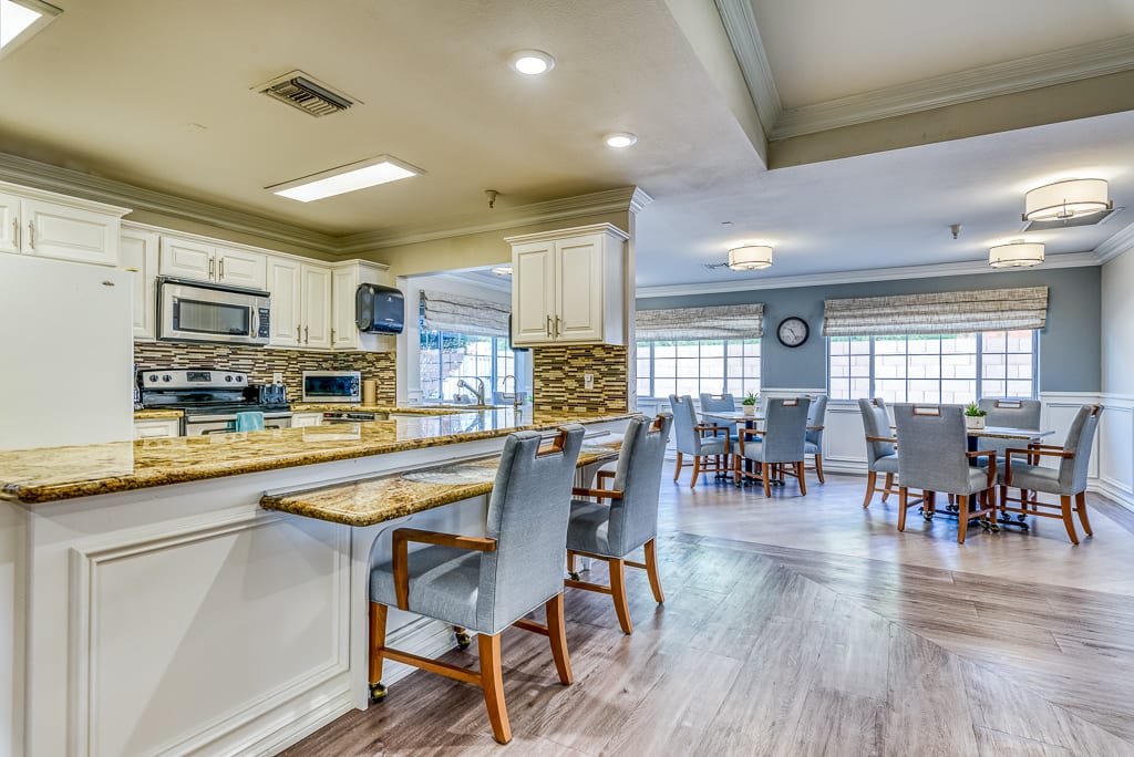 A spacious kitchen with an open concept dining area, featuring modern appliances and bright lighting.