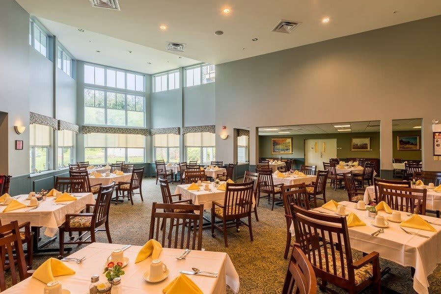 A spacious and well-lit dining area with neatly arranged tables and chairs.