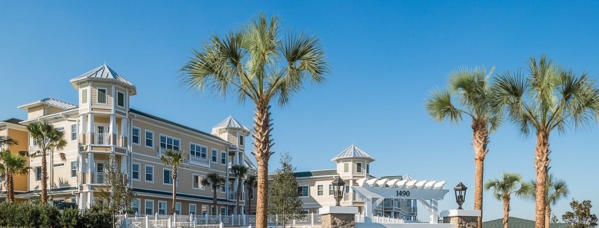 A picturesque view of a coastal resort with palm trees under a clear blue sky.