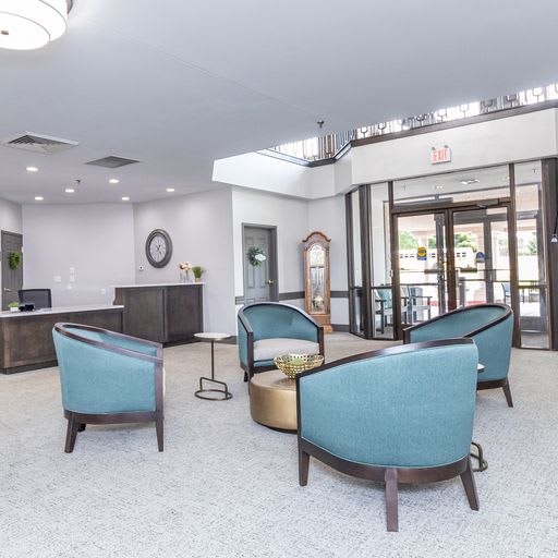 Modern lobby area with blue chairs and a reception desk.