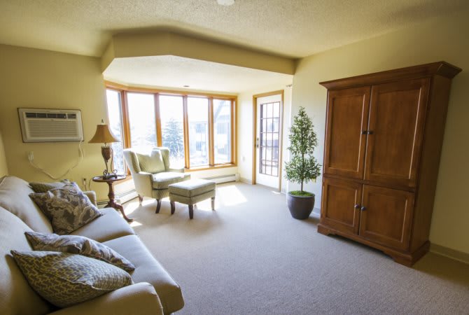 A cozy living room with large windows and comfortable seating.